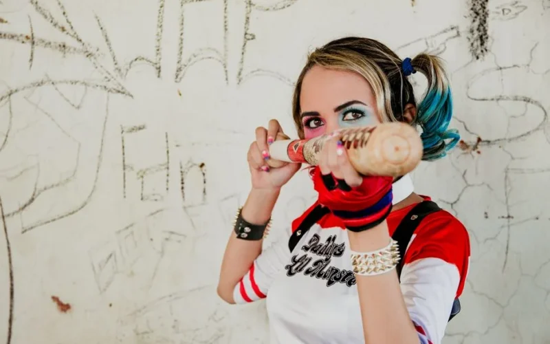 Vibrant cosplay photo of a woman in Harley Quinn inspired costume with baseball bat.