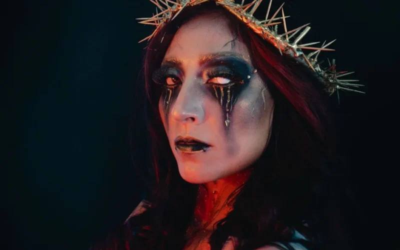 Captivating gothic portrait of a woman with artistic makeup and a thorn crown, dramatic lighting.
