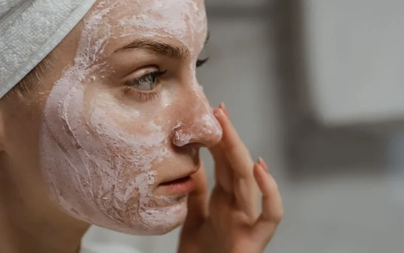 Close-up of a woman applying facial cream as part of her skincare routine, enhancing skin health.