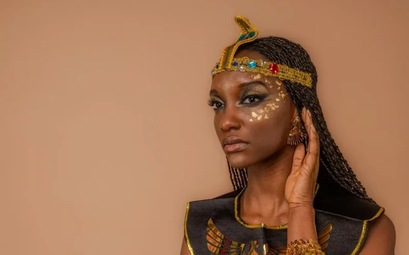 Beautiful portrait of a woman in Egyptian-inspired attire with creative makeup and jewelry.