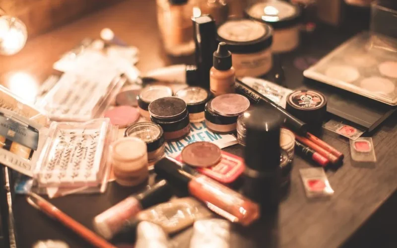 Various cosmetics and makeup products displayed on a vanity table. Ideal for beauty and fashion themes.