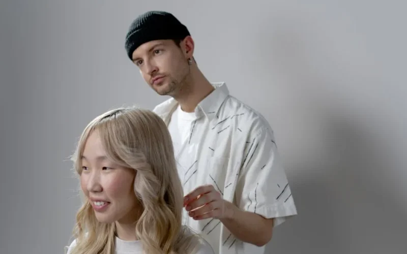 A hairstylist creating a fashionable look in a contemporary salon setting with attentive focus.