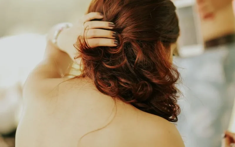 Sophisticated back view of a woman with styled red hair in natural light.