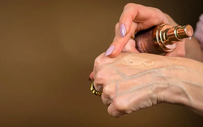 A detailed shot showing foundation being applied to hand skin care routine.