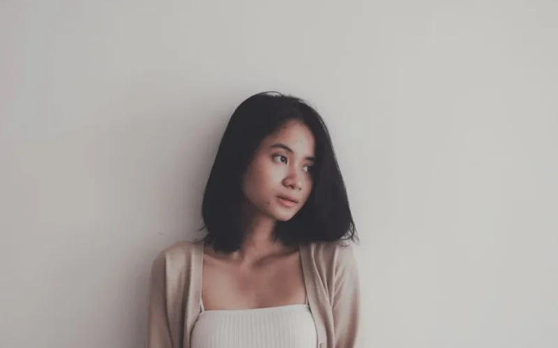Portrait of an Asian woman with short dark hair against a minimalist white background.